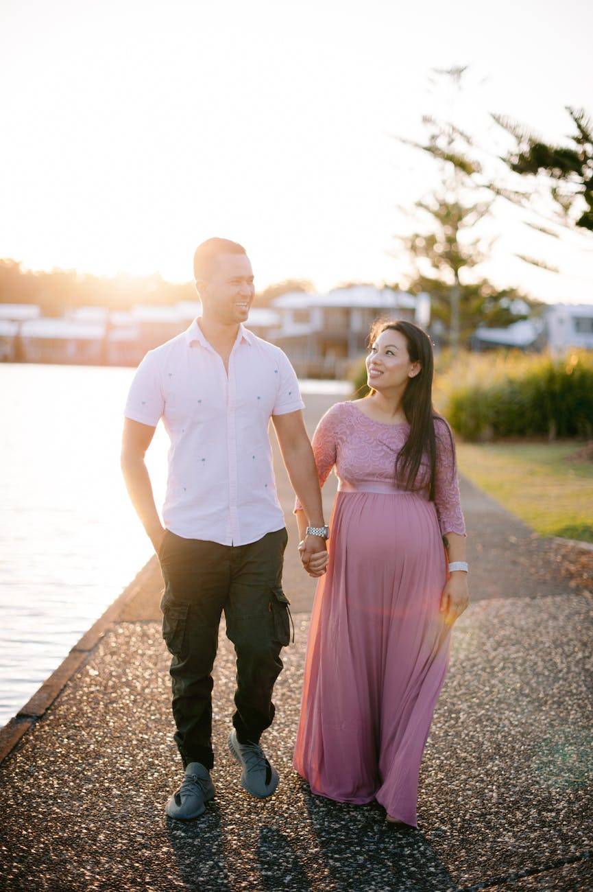 future parents walking along the promenade holding hands